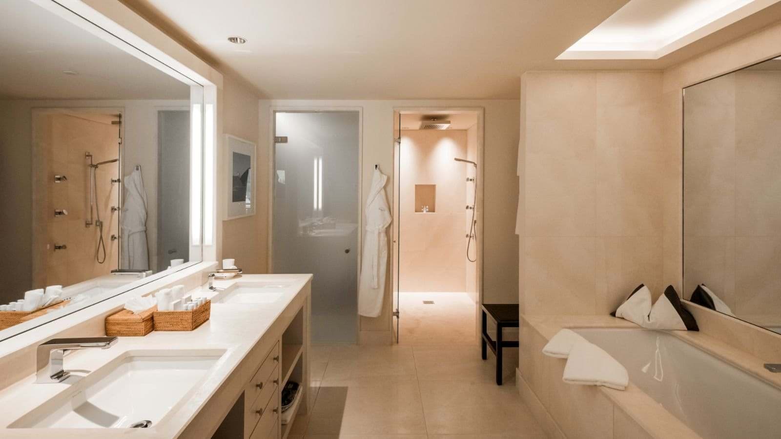 Bathroom with dual vanity, soaking tub, and walk-in rainfall shower