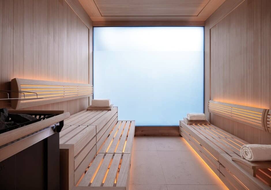 Cedar dry sauna with multi-level seating and frosted privacy window