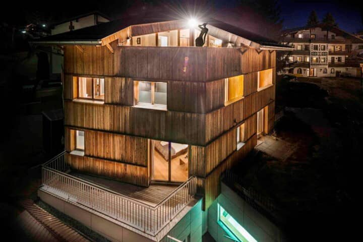 Multi-level timber chalet with wrap-around deck and top-floor terrace