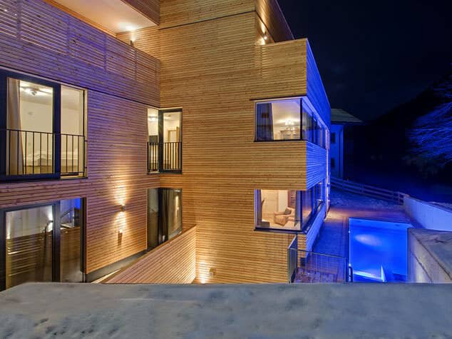 Chalet exterior at night with illuminated year-round outdoor pool