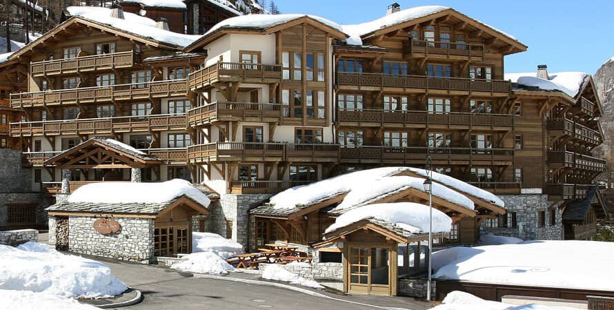 Ski-in/ski-out chalet exterior featuring private balconies and outdoor picnic seating