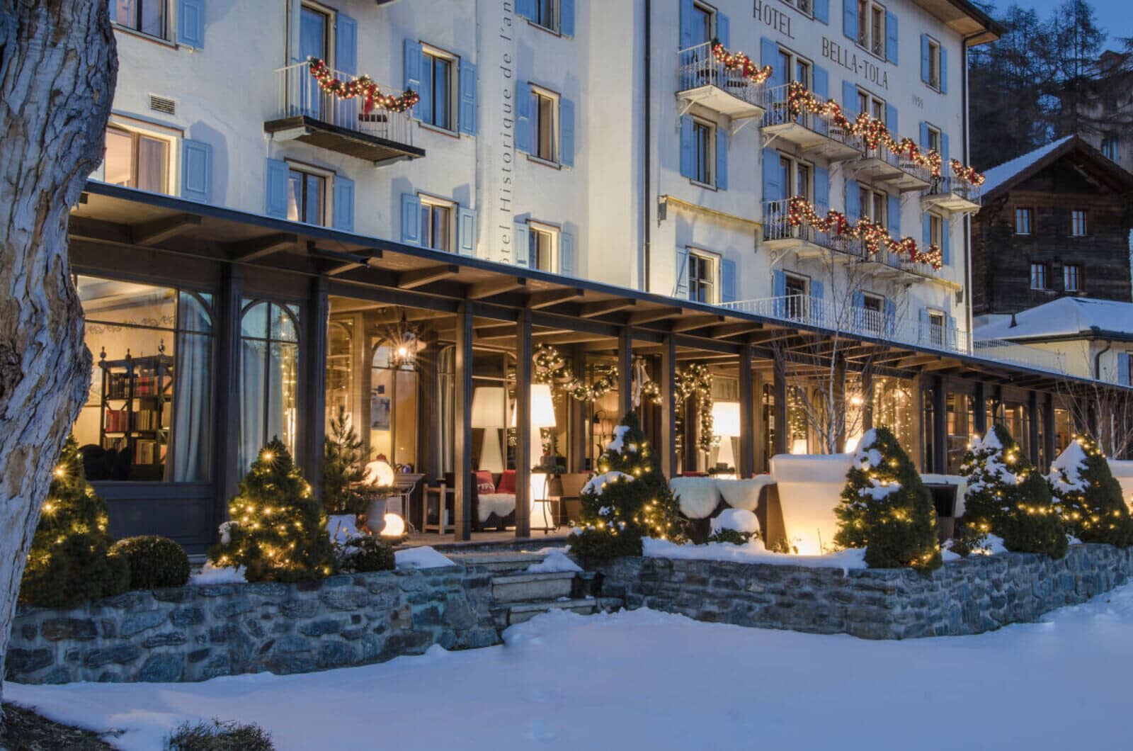 Covered outdoor terrace with heated lounge seating and festive lighting