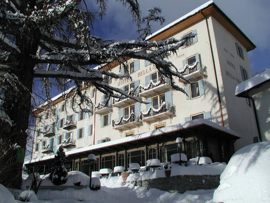 Historic hotel facade with private balconies and snow-covered terrace seating