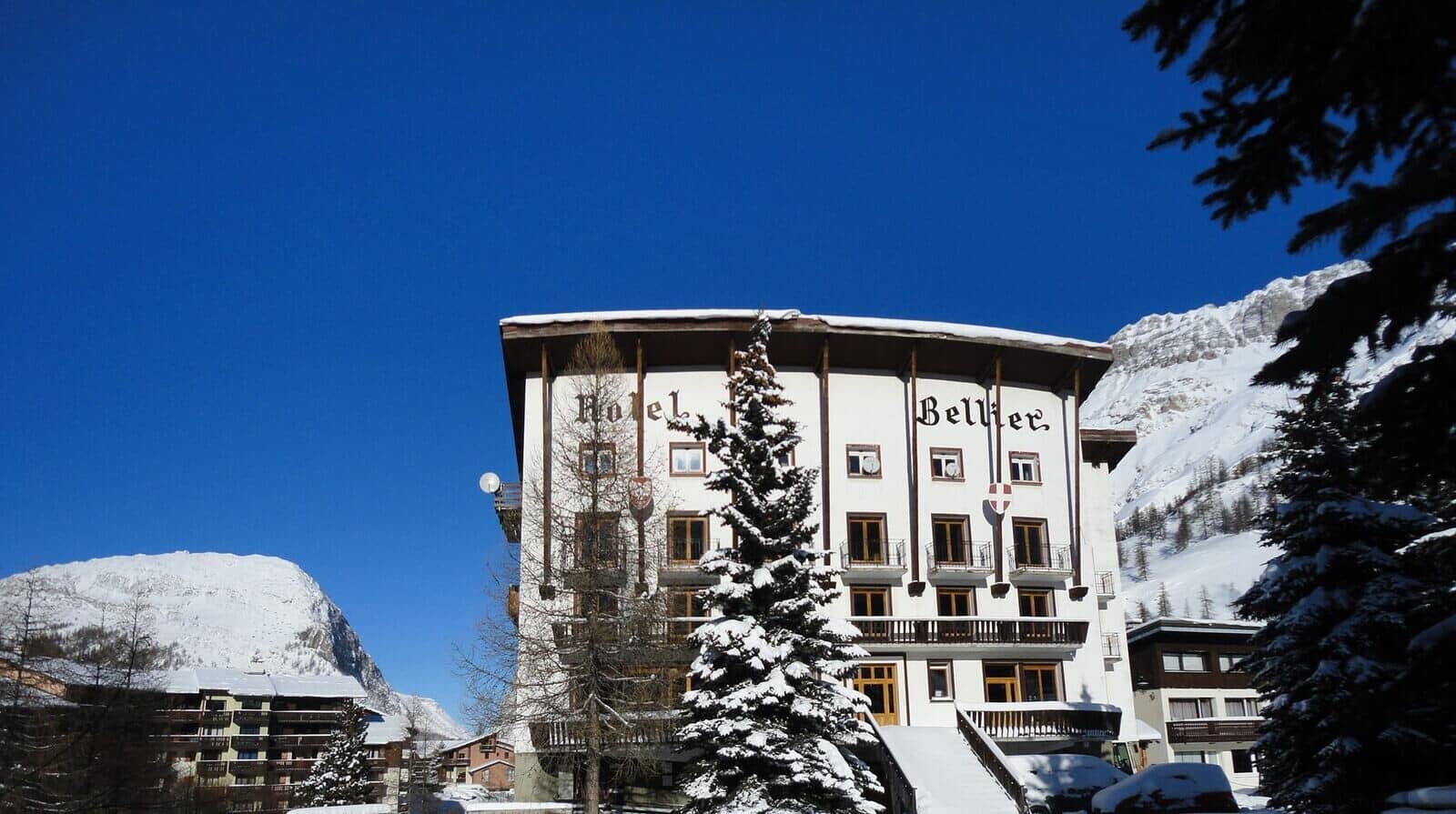 Hotel exterior with south-facing balconies and views of the surrounding massif