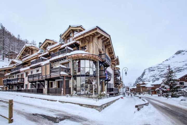 Ski-in chalet exterior with private balconies and floor-to-ceiling glass atrium
