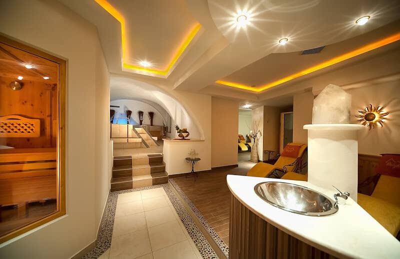 Wellness area with wood-lined sauna and elevated whirlpool bath