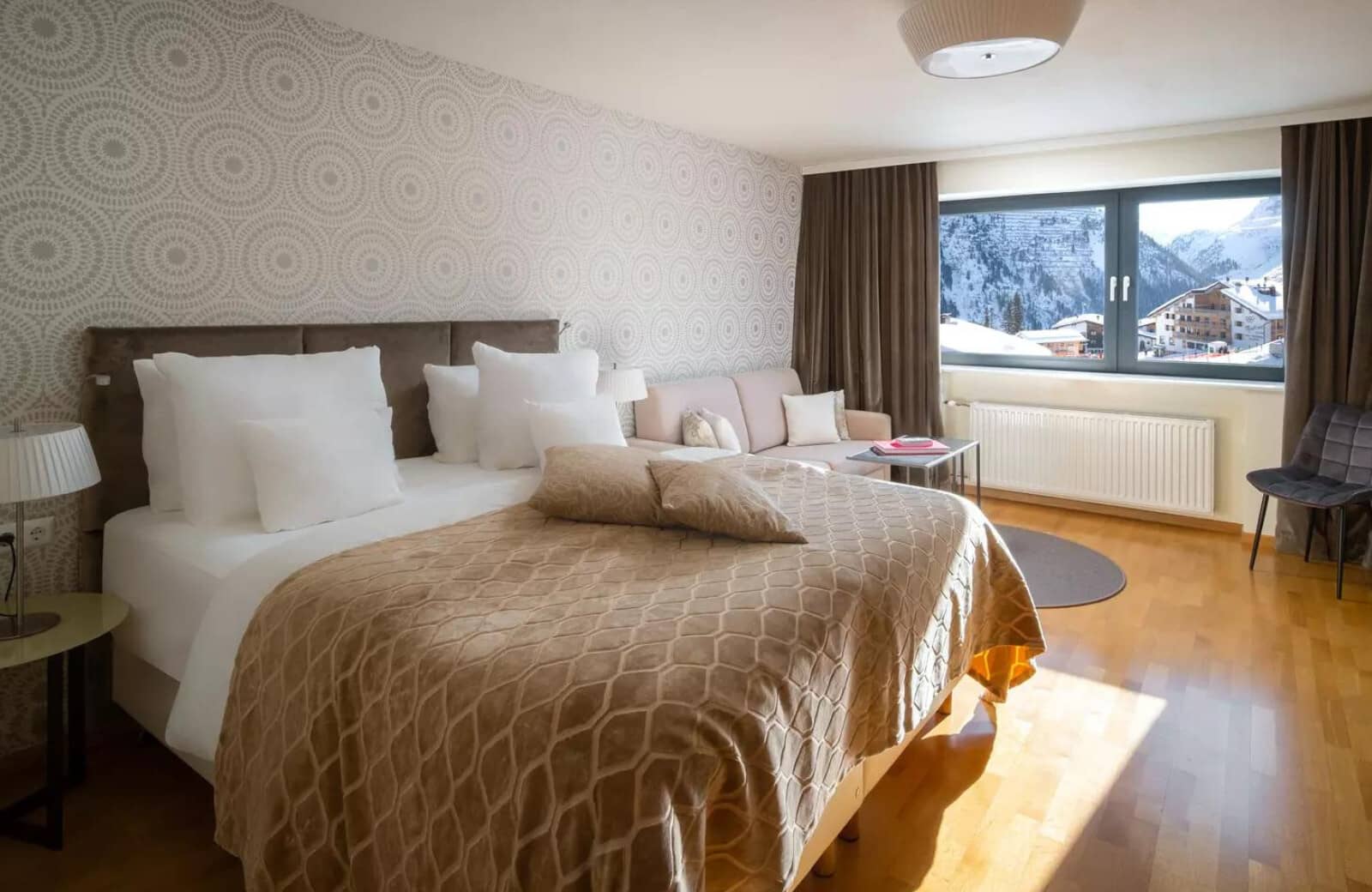 King bed and sofa seating with views of the mountain village