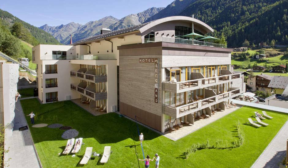 Hotel exterior with climbing wall, private balconies, and mountain valley views