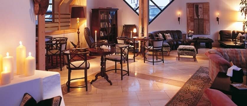 Lounge area with leather sofas, marble floors, and several seating clusters