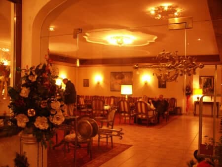 Lobby lounge with vintage armchairs and ornate brass chandeliers