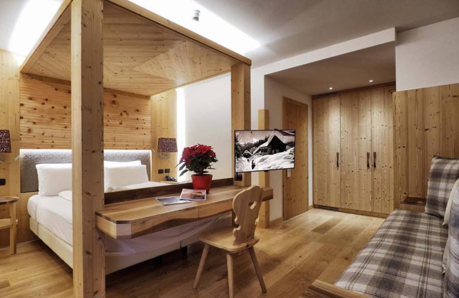 Bedroom with wooden canopy bed, integrated desk, and built-in closets