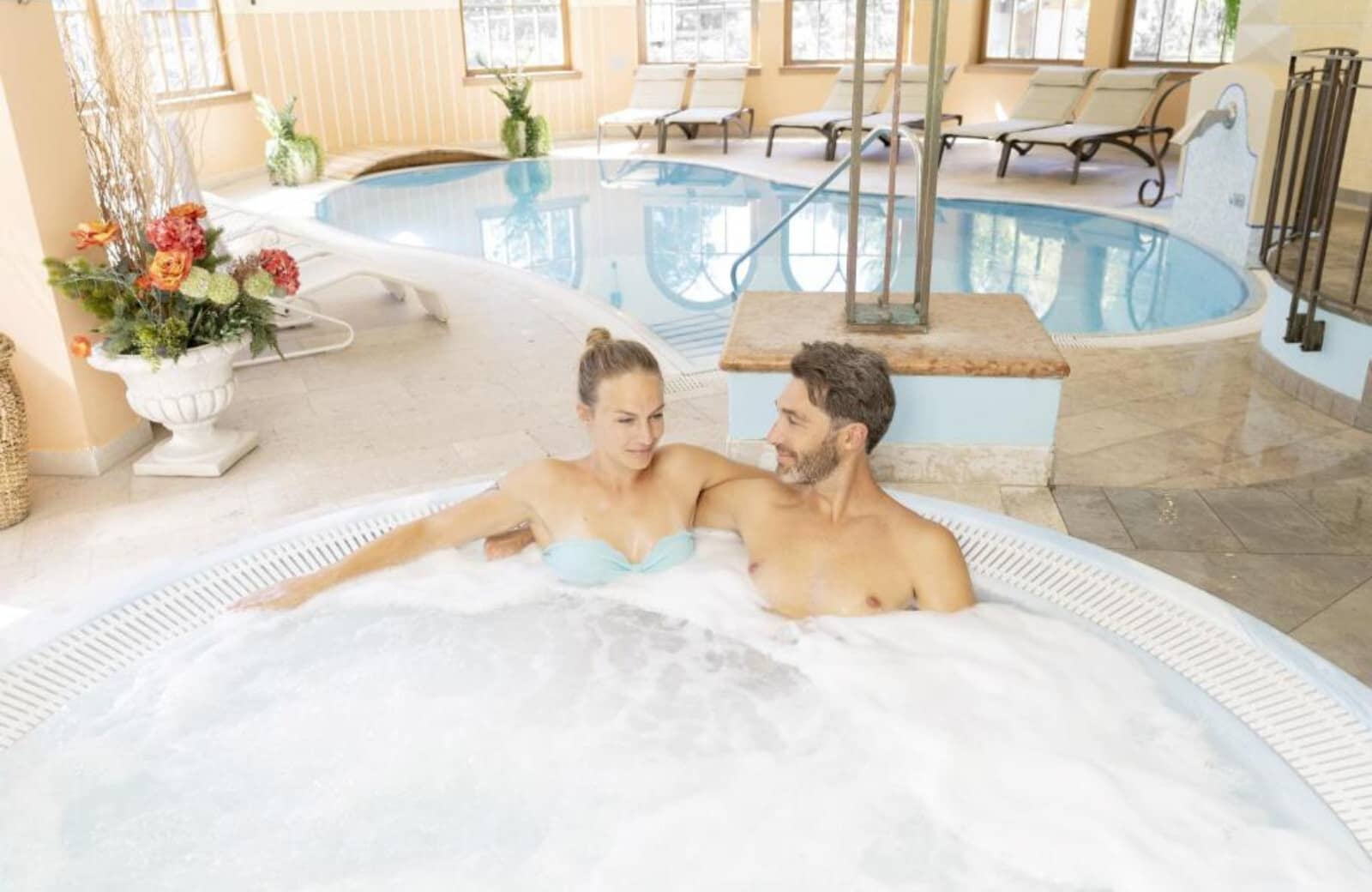 Wellness area with circular hot tub and adjacent swimming pool