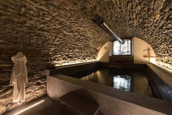 Indoor plunge pool with vaulted stone ceiling and ambient ledge lighting