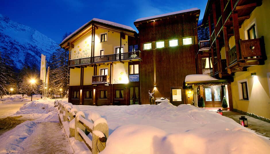 Chalet exterior at dusk with mountain views and private balconies