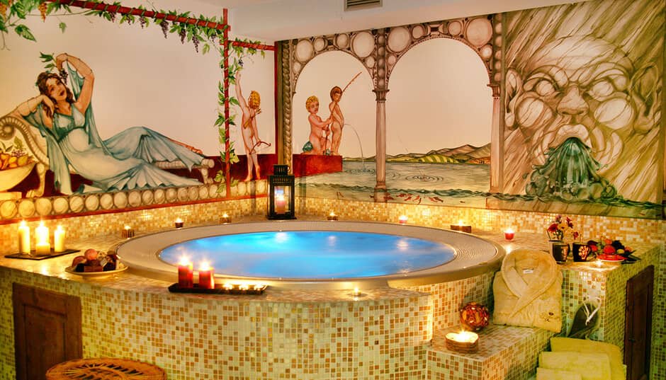 Indoor circular hot tub with custom murals and mosaic tile surround