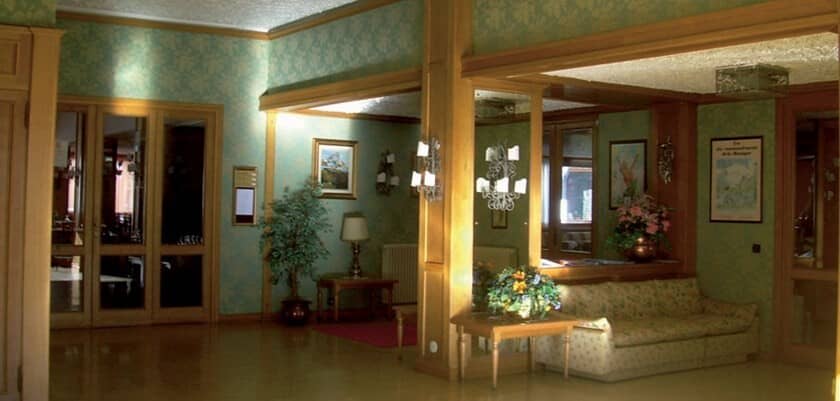 Lobby seating area featuring wood paneling and floral wallpaper