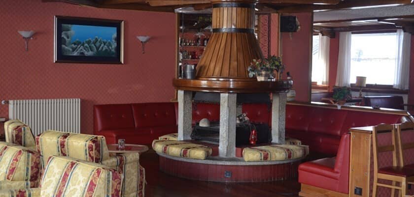 Lounge area with central stone fireplace and cushioned bench seating