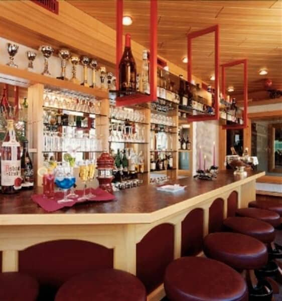 Indoor home bar with seating for eight and glass shelving