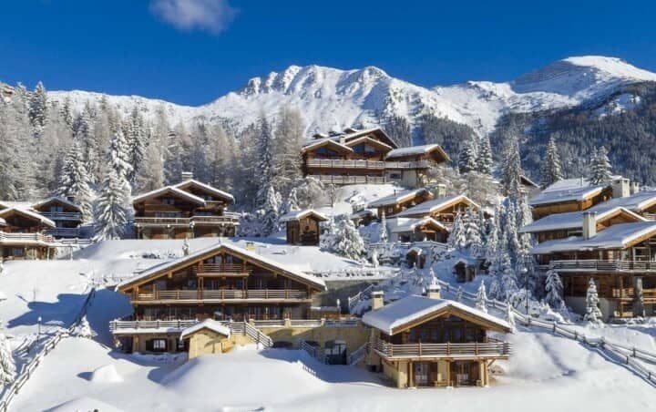 Alpine chalets with multi-level balconies and mountain peak views