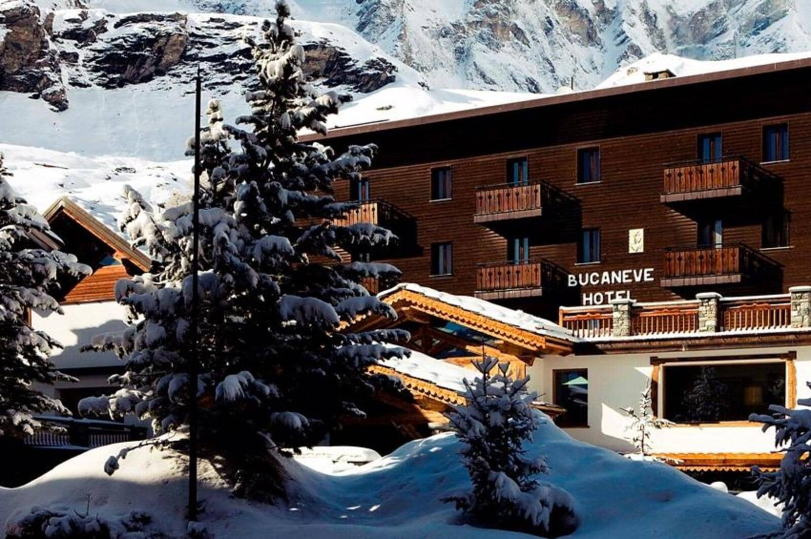 Timber-clad exterior with private balconies and mountain backdrop