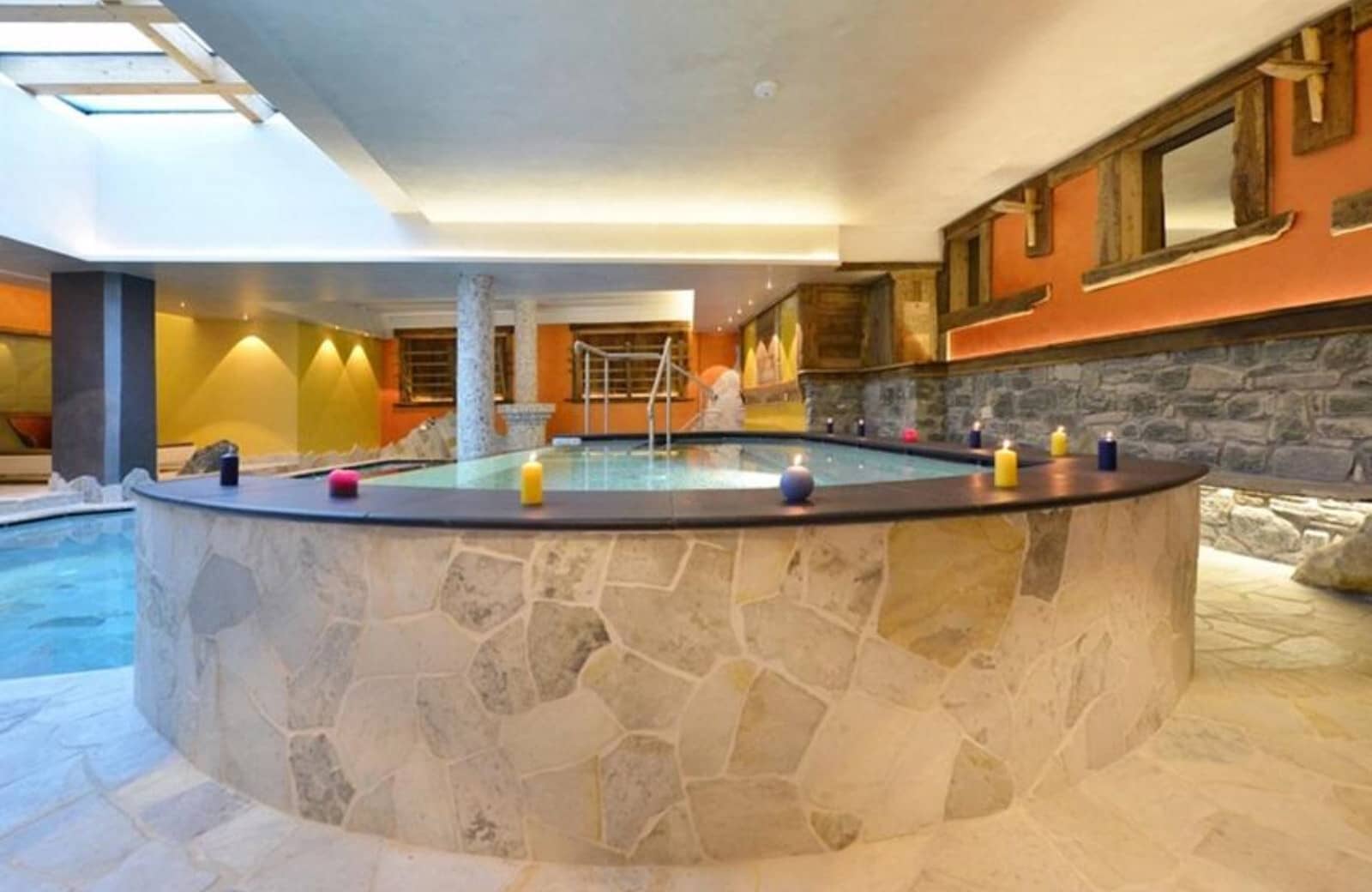 Indoor pool with natural stone finishes and overhead skylight