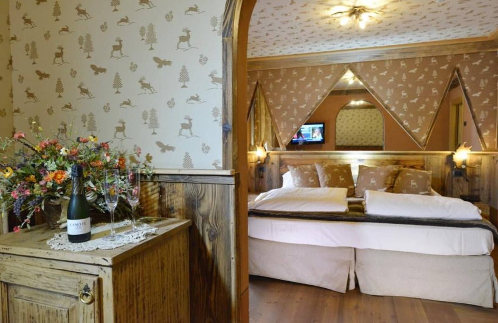 Bedroom with king bed and wall-mounted TV; rustic wood paneling