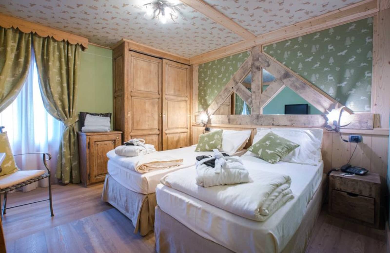 Twin bedroom with alpine-themed wallpaper and built-in wardrobe