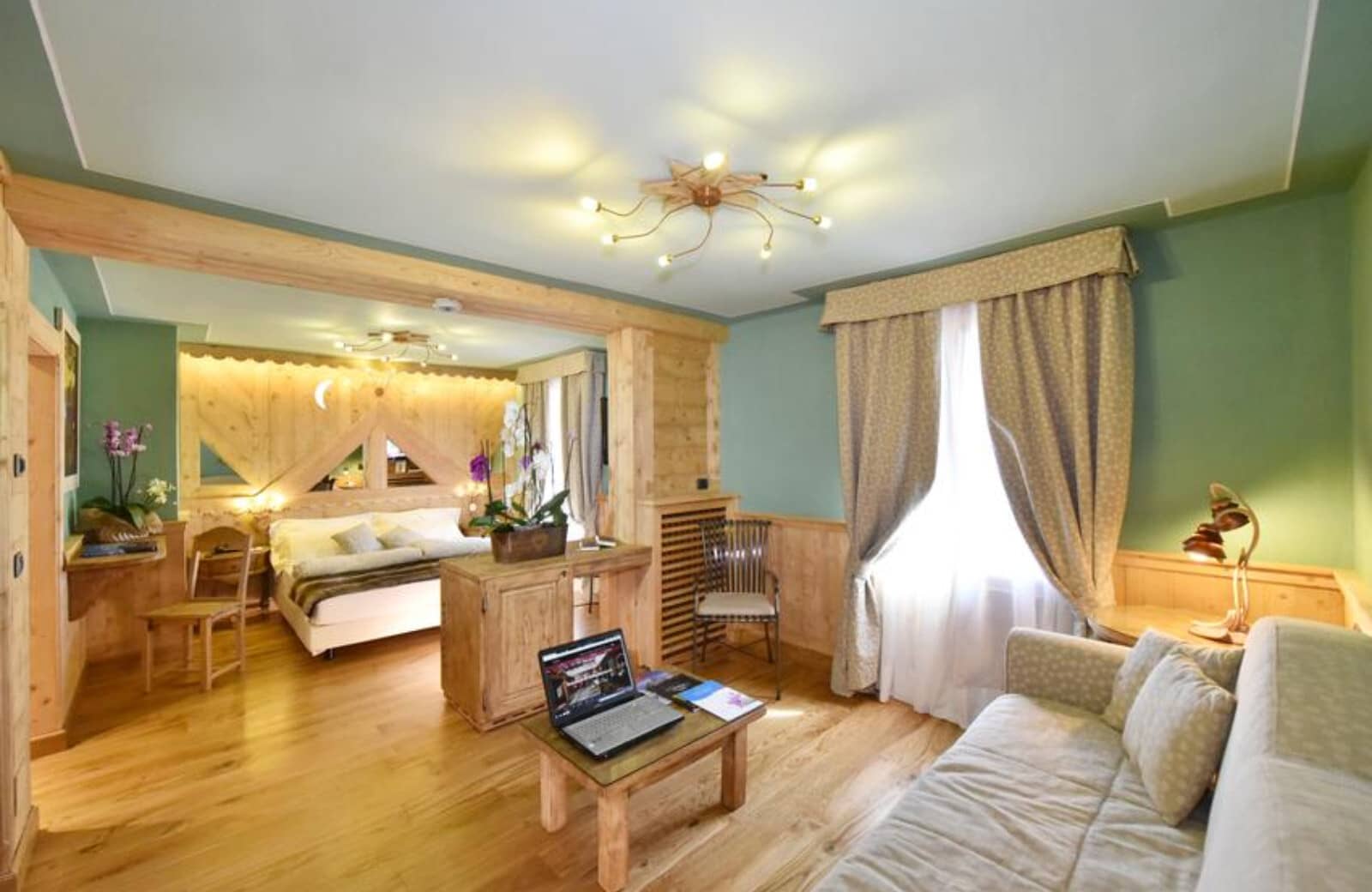 Suite with king bed and separate living area; wood-paneled walls