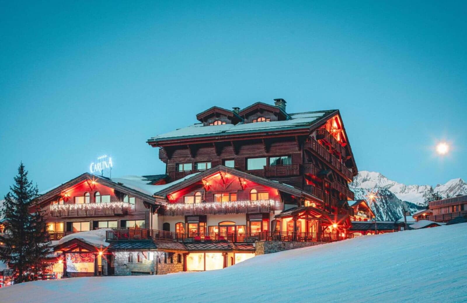 Ski-in/ski-out chalet exterior with illuminated balconies and mountain views