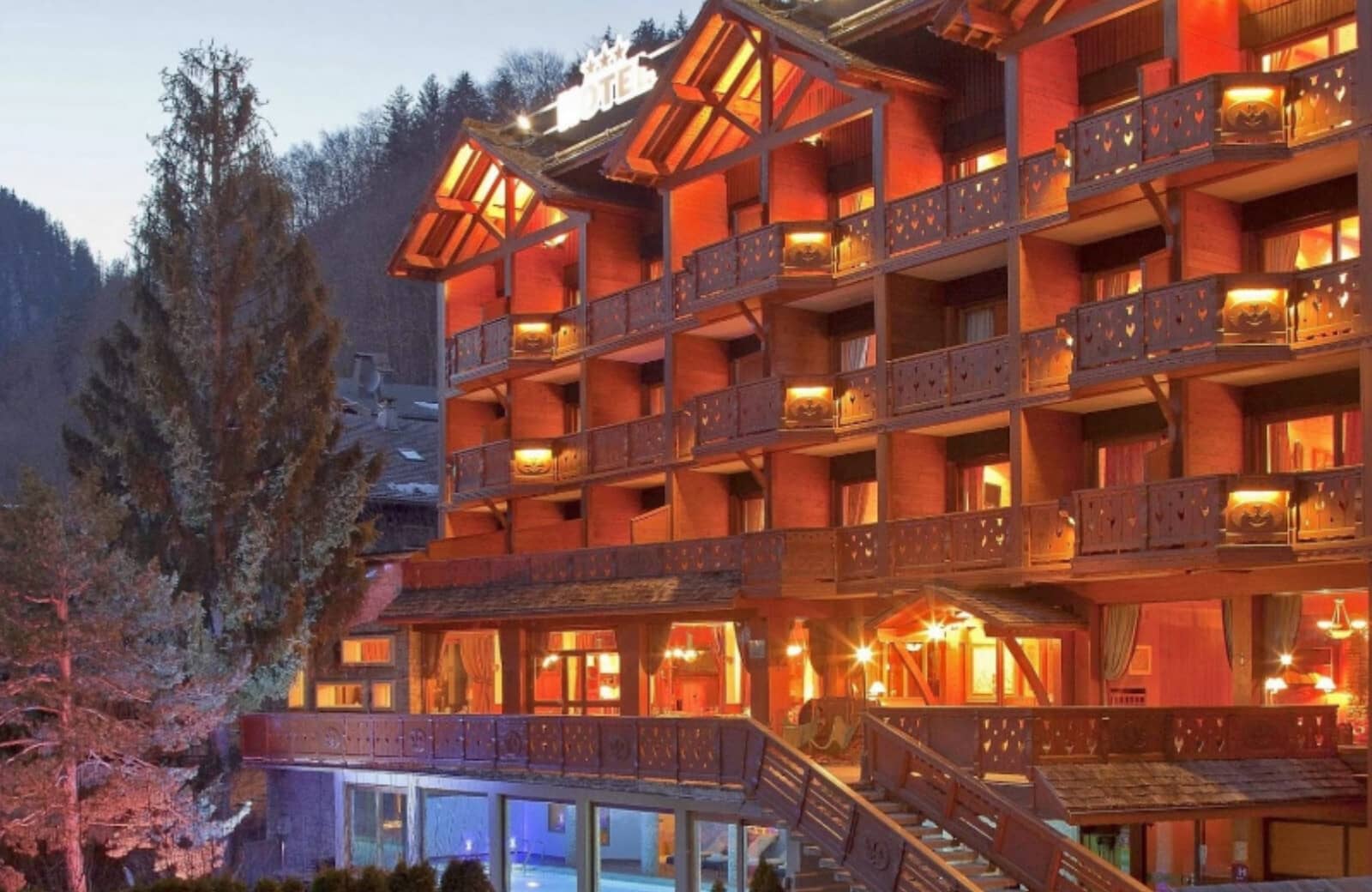 Chalet-style exterior with private balconies and heated indoor-outdoor pool