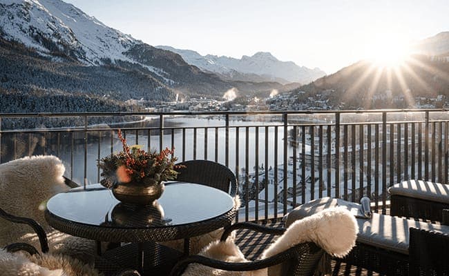 Private balcony with lake views, cafe seating, and faux-fur throws