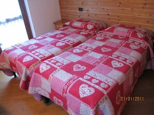 Guest bedroom with two twin beds and wood-paneled accent wall