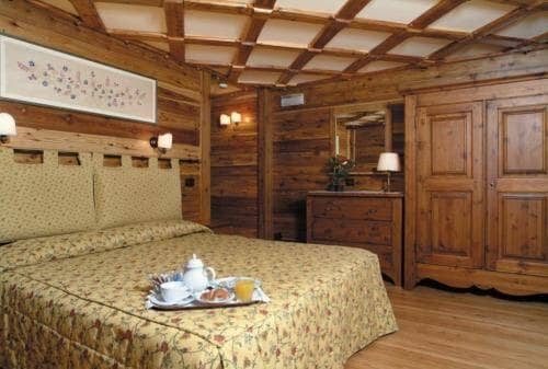 Wood-paneled bedroom with queen bed and hand-carved armoire