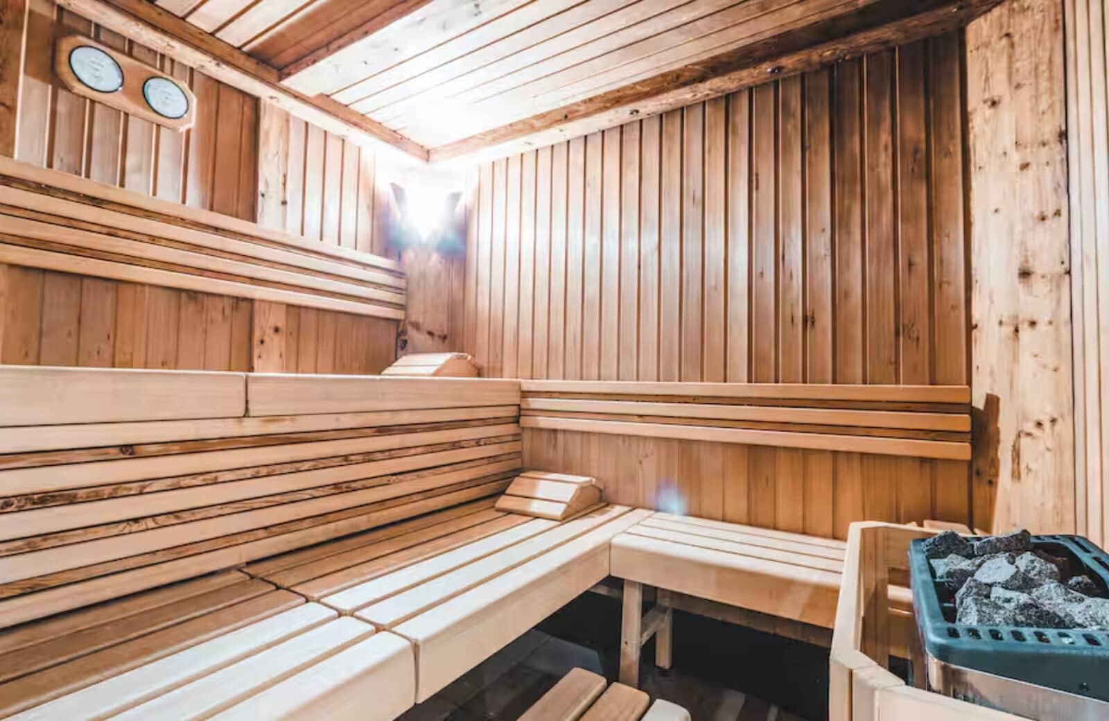 Indoor sauna with tiered seating and integrated rock heater