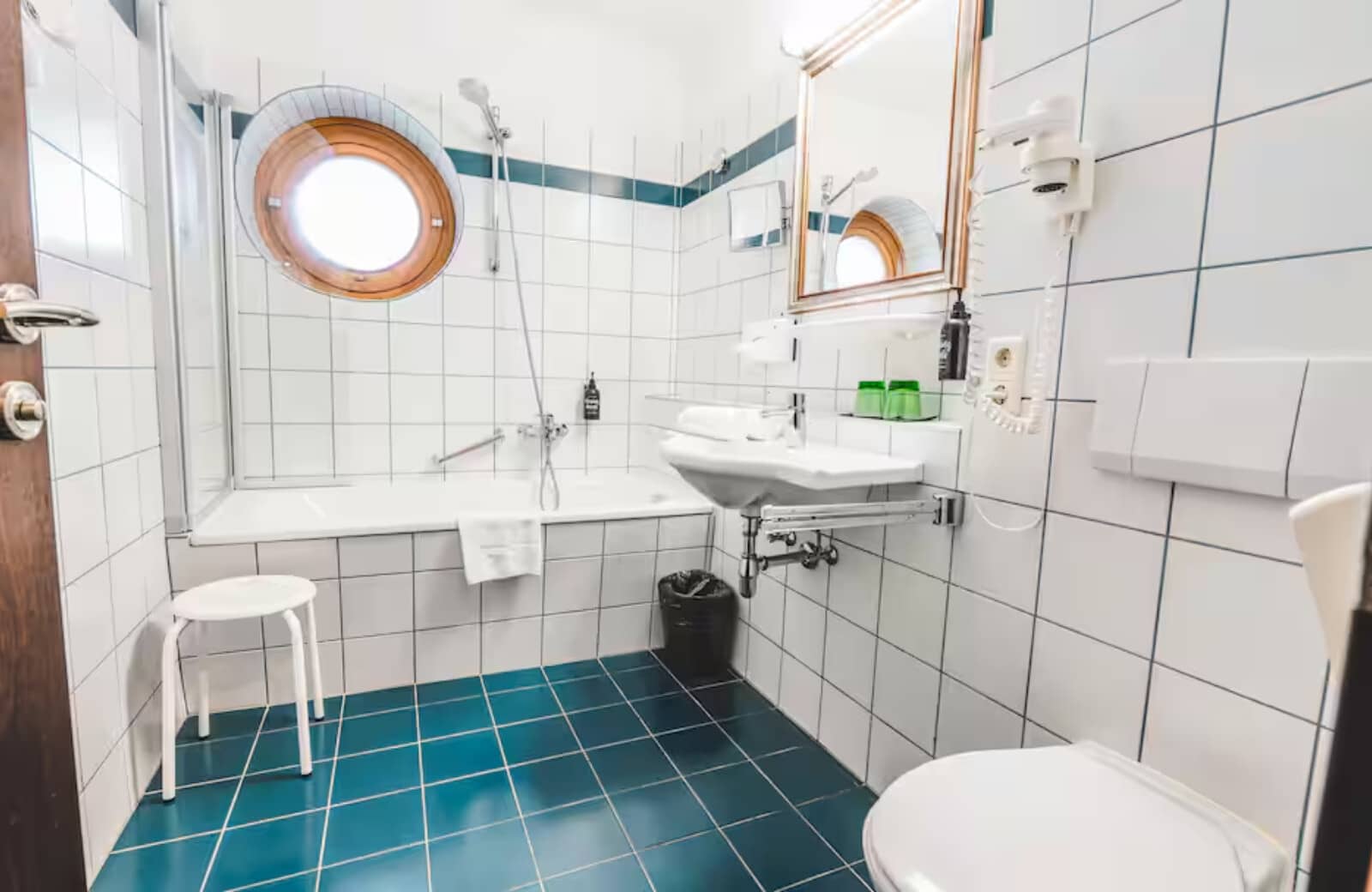 Bathroom with tub-shower combo and nautical porthole window