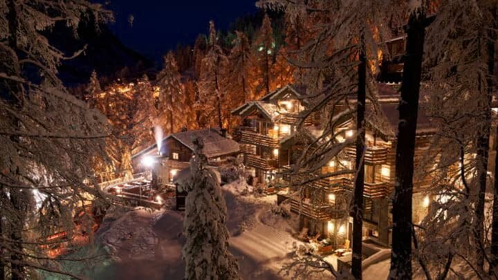 Chalet exterior with multi-level balconies and snowy forest setting
