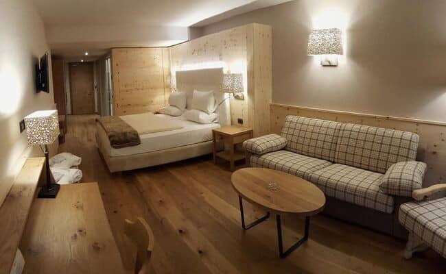 Guest suite with king bed, sofa seating area, and hardwood floors