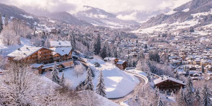 Elevated view of snow-covered village and surrounding mountain peaks