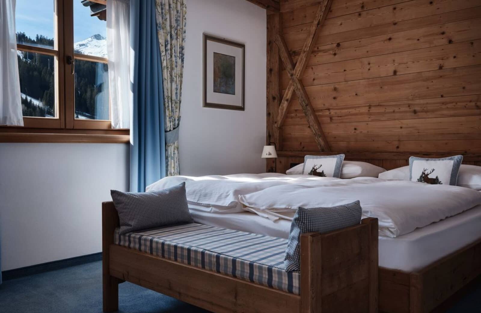 Guest bedroom with two twin beds and alpine mountain views