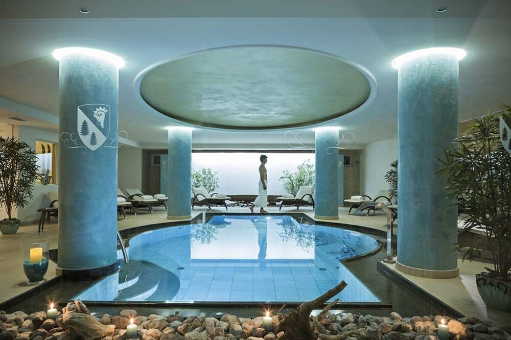 Indoor heated pool with lounge seating and integrated stone lighting
