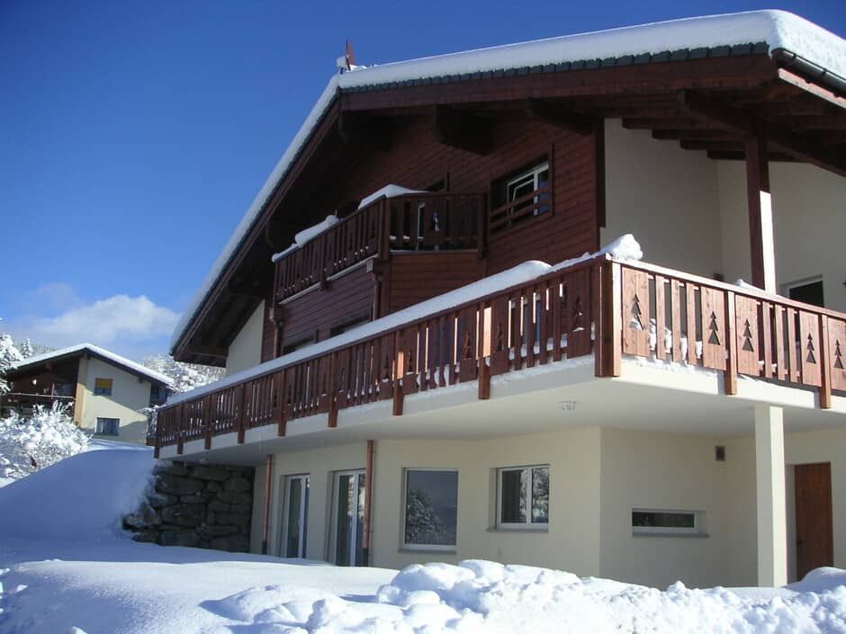 Chalet exterior with wrap-around balcony and upper-level sun terrace