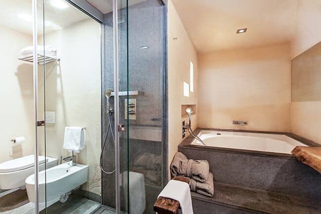 Bathroom with glass walk-in shower, soaking tub, and wall-mounted bidet