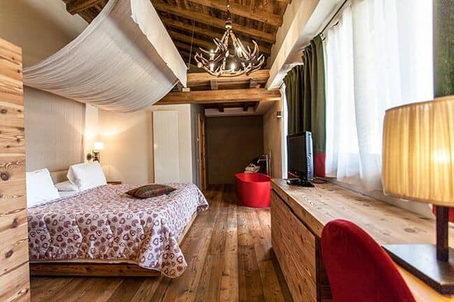 Bedroom featuring canopy bed and private in-room soaking tub