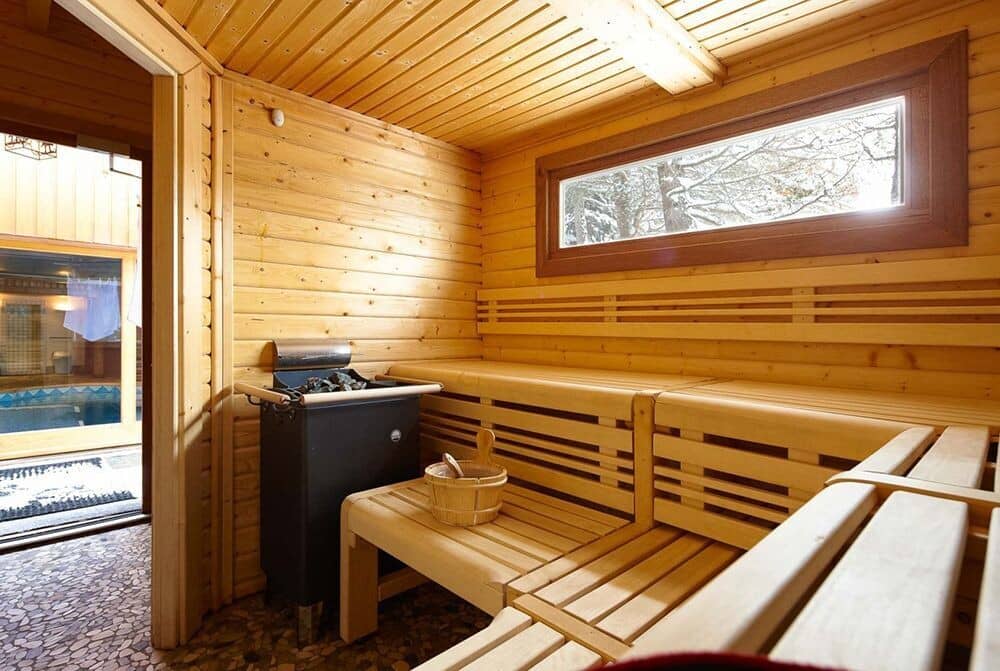 Wood-lined sauna with electric heater and pool access