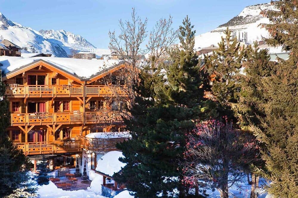 Ski-in chalet exterior with private balconies and ground-floor patio seating