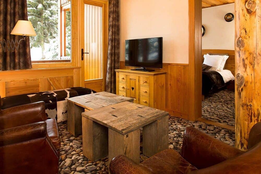 Sitting area with leather armchairs and view into the adjacent bedroom