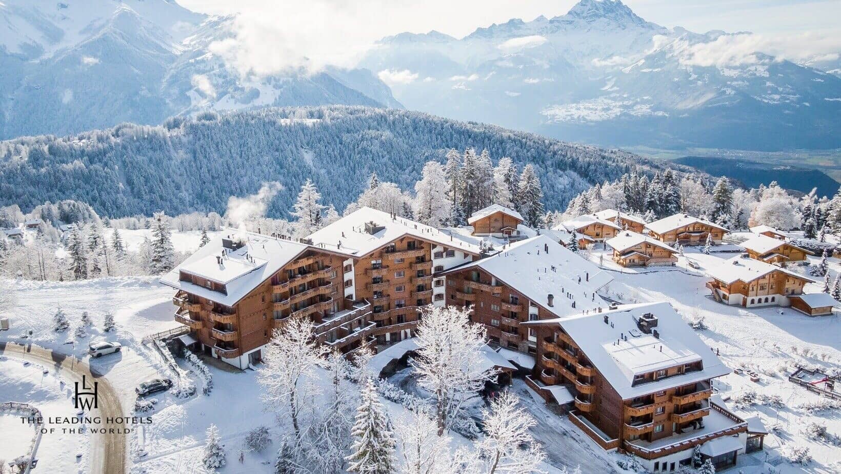Aerial view of slope-side chalets with private balconies and mountain views