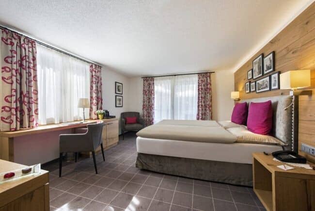 Guest bedroom with king bed, dedicated workspace, and armchair