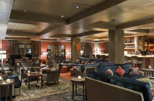 Lounge area with coffered ceilings, sectional seating, and full-service bar