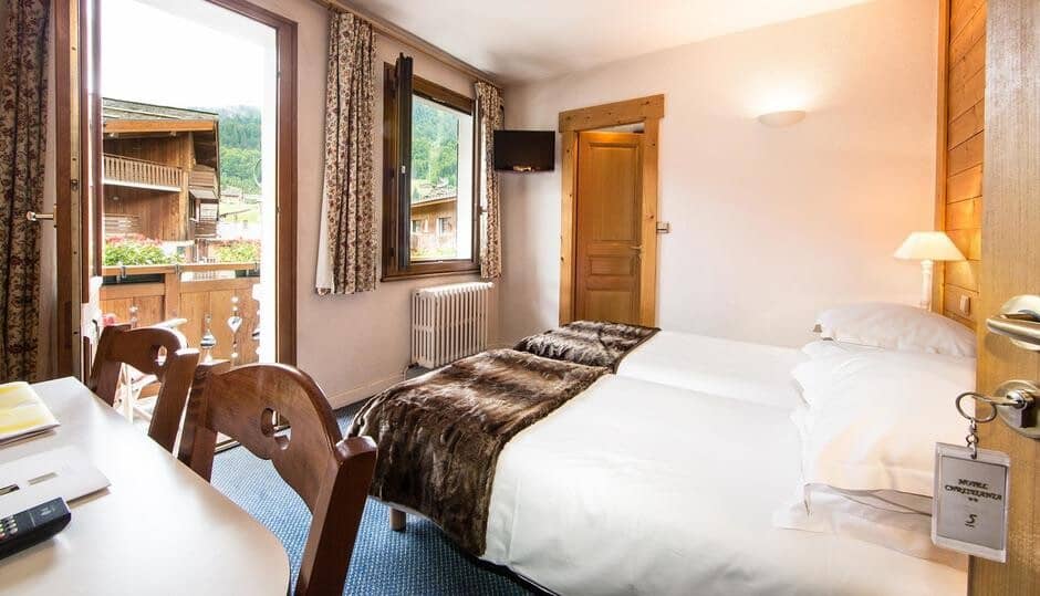 Guest bedroom with twin beds and private balcony access